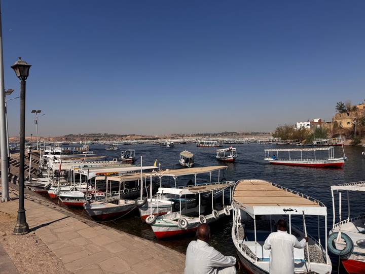 Dozens of small motorboats moored along Nile embankment under clear sky