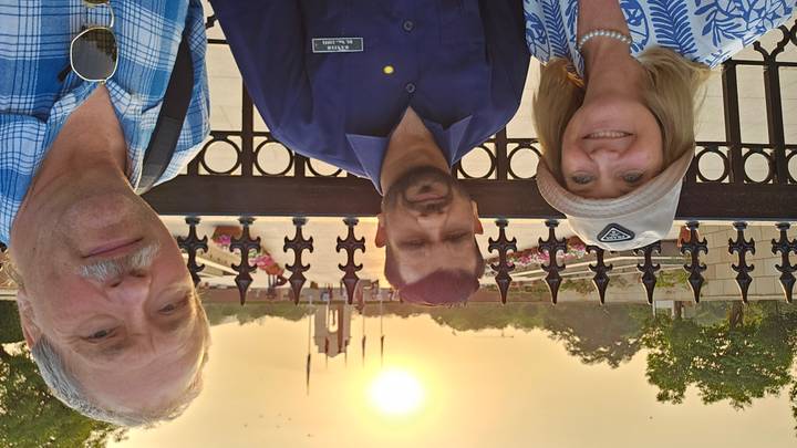 Selfie with guide and travelers in front of India Gate at sunset with glowing orange sky.