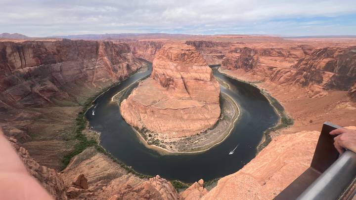 Panoramic view of Horseshoe Bend where the Colorado River loops around a sandstone butte.