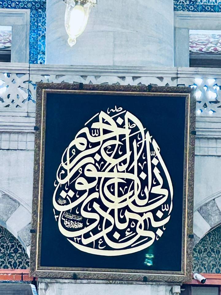 Framed panel of ornate Arabic calligraphy displayed inside an Istanbul mosque.