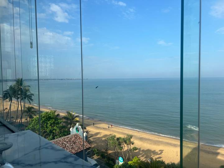 View through glass panels of a calm tropical beach and blue sea.