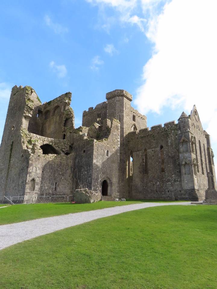 Ruins of the Rock of Cashel stand against a bright blue Irish sky.