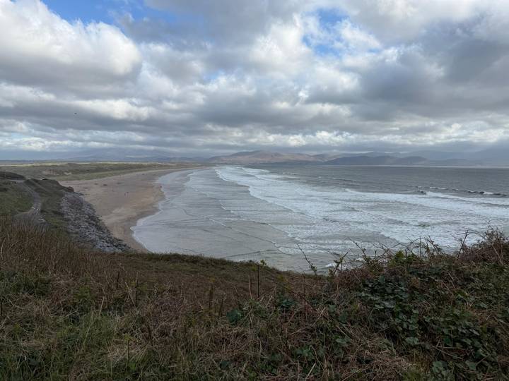 Wide sandy Atlantic beach and rolling surf beneath cloudy skies.
