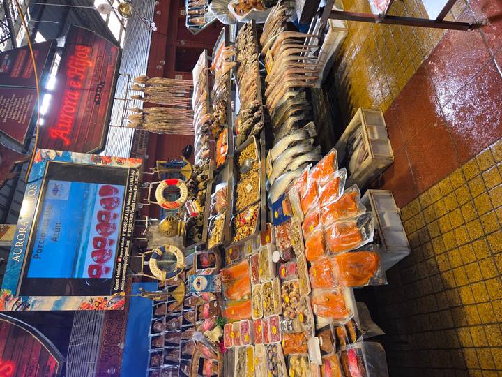 A vibrant seafood market stall displays fish, shellfish and dried products.