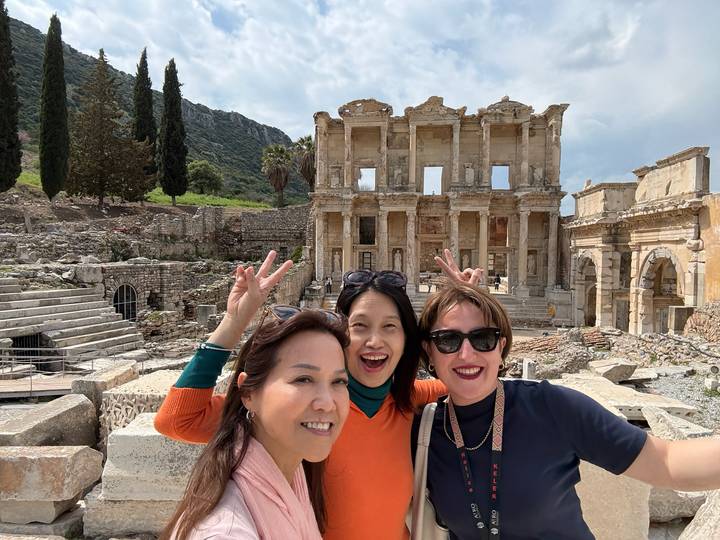 Three friends flashing peace signs in front of the iconic Library of Celsus in Ephesus.
