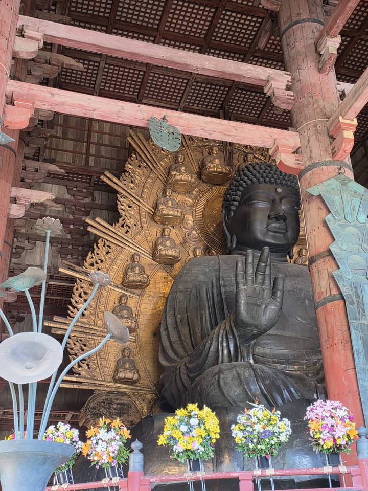 Massive bronze Great Buddha statue at Todai-ji temple with intricate golden halo of mini Buddhas.