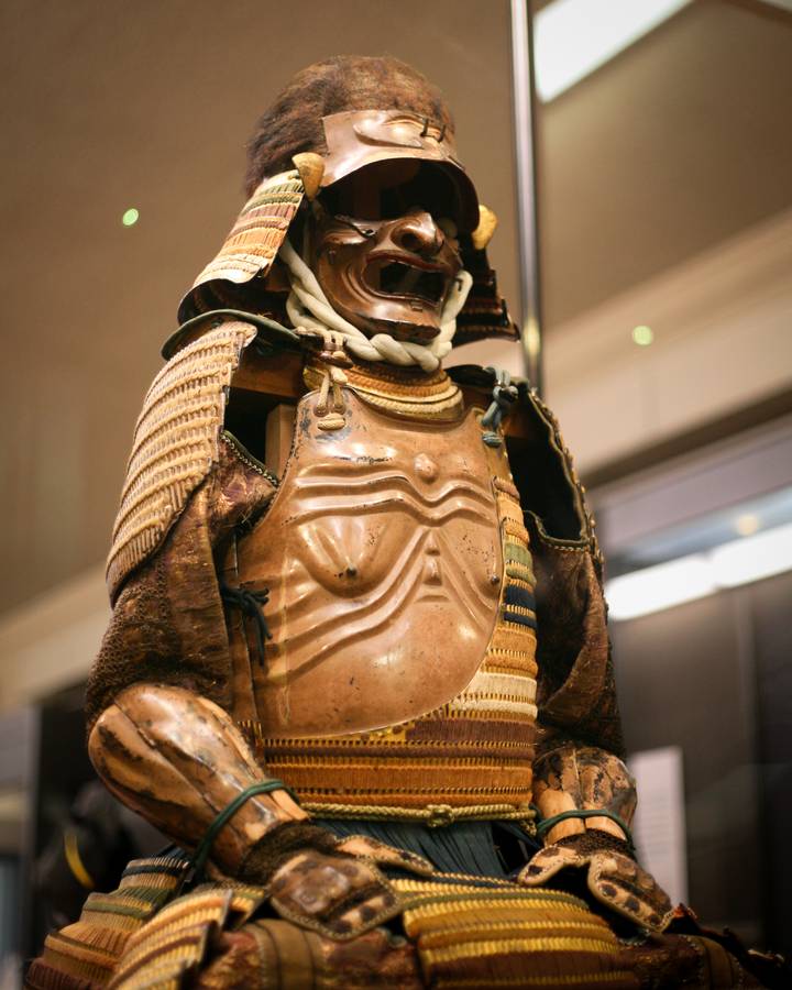 Detailed view of traditional Japanese samurai armor displayed in museum lighting.