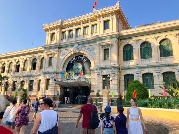 Colonial yellow Central Post Office façade with ornate details and tourists milling about.