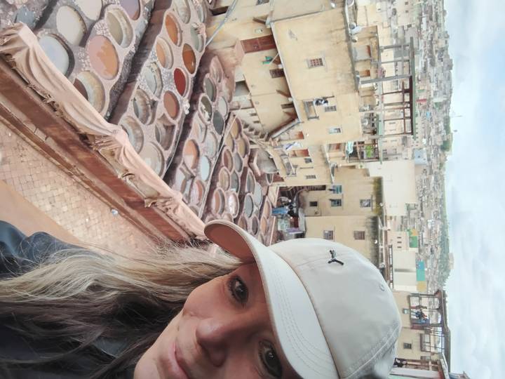 Close-up selfie capturing the multi-level dye pits of Fes tanneries in the background.