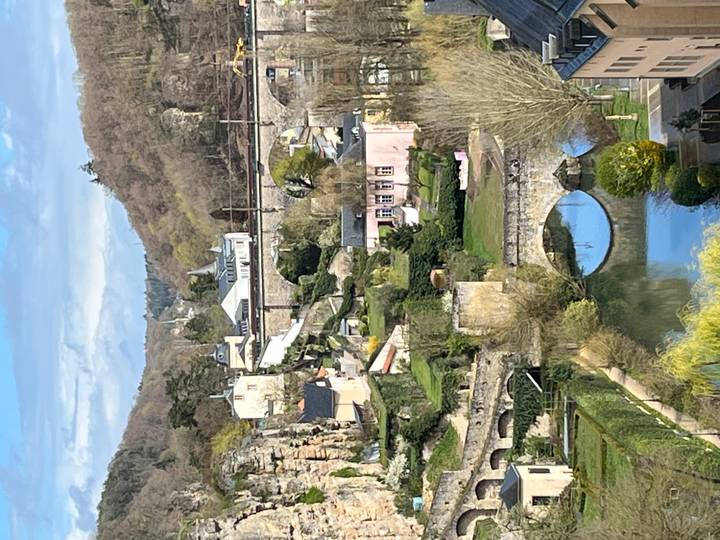 Picturesque old town valley with pastel houses, stone bridges and wooded hills in early spring.