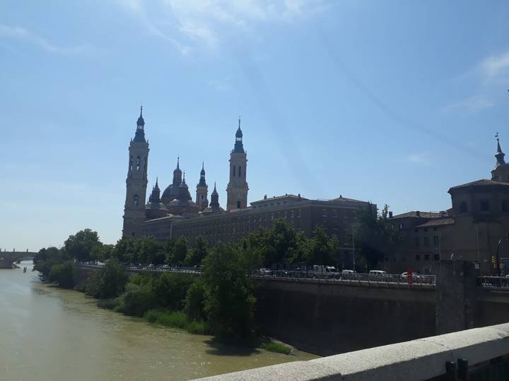 Riverside skyline of Zaragoza featuring the domes and towers of the Basilica del Pilar.