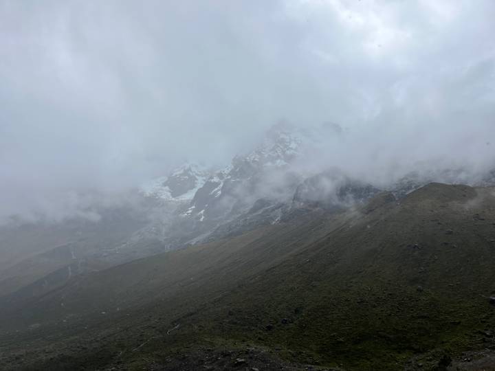Misty, cloud-shrouded Andean peak barely visible through thick fog.