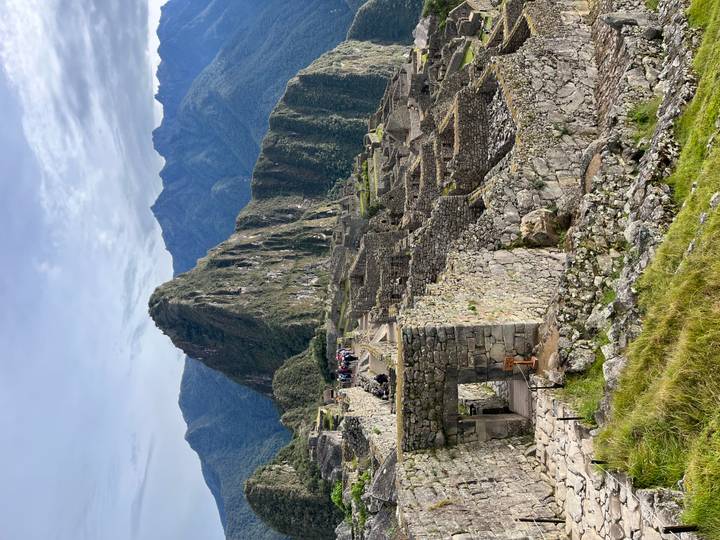 Classic stone ruins and Huayna Picchu peak at Machu Picchu on bright morning.