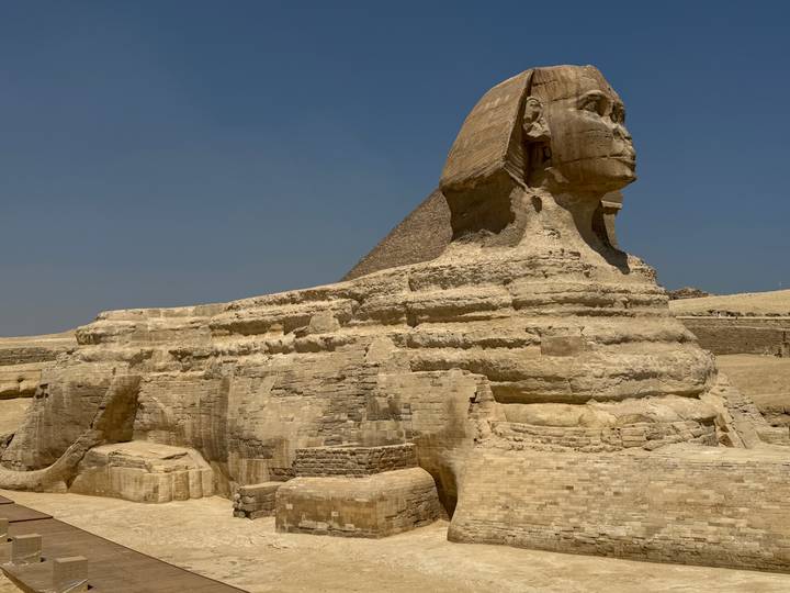 Side profile of the Great Sphinx of Giza set against a clear desert sky.