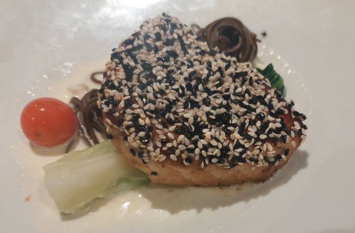 Seared fish fillet crusted with black and white sesame seeds served with noodles and bok choy.