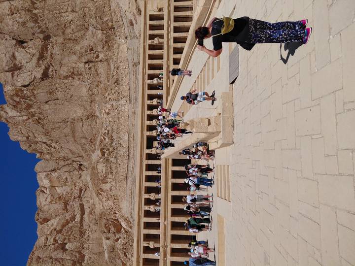 Grand temple of Hatshepsut at Deir el-Bahri with long ramp and crowds of visitors against steep cliffs