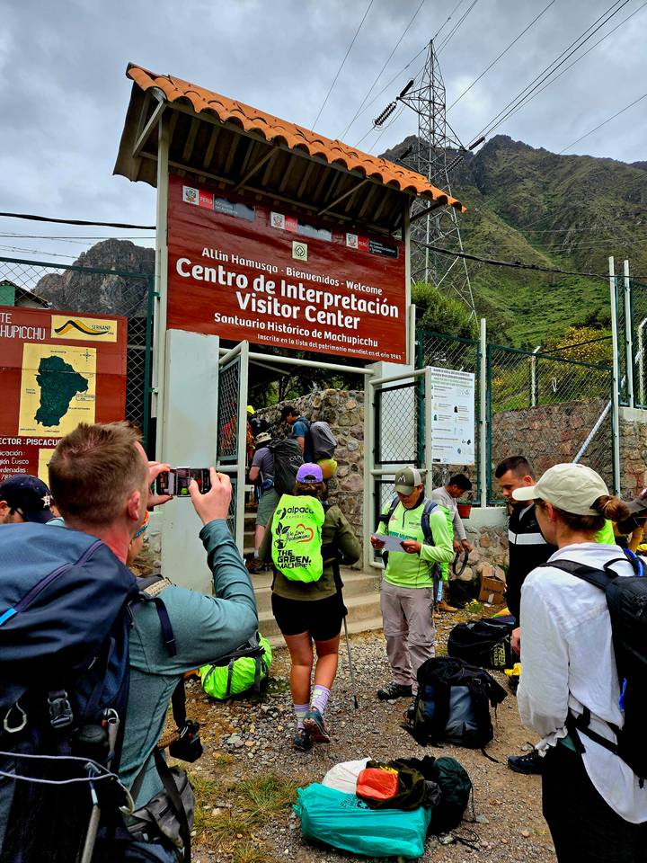 Visitors queue at the Inca Trail visitor center entrance while taking photos