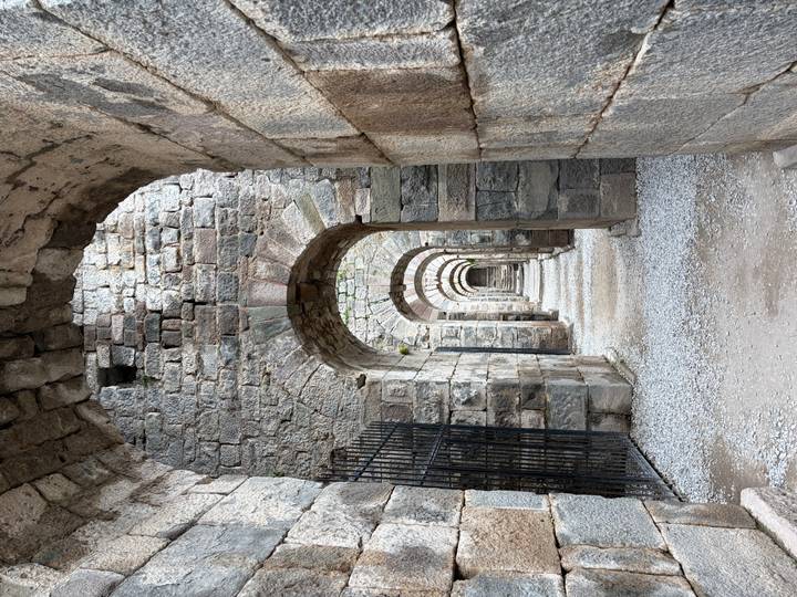 Stone vaulted arcade of ancient Roman ruins with repeating arches