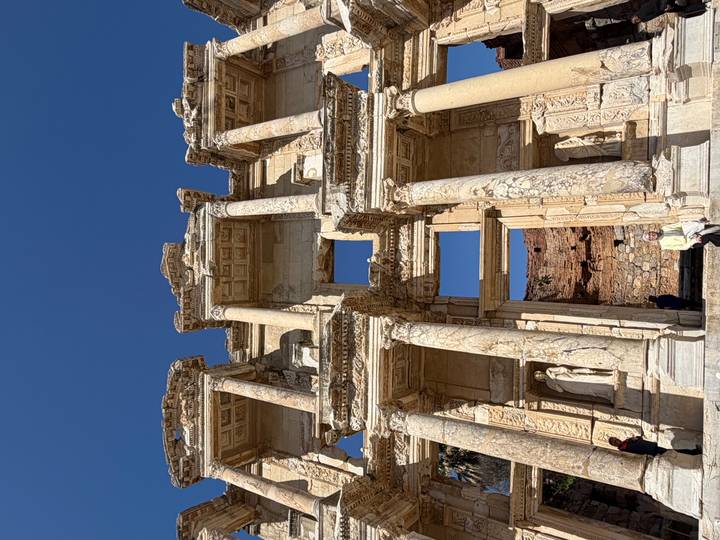 Upward view of restored Celsus Library façade under flawless blue sky