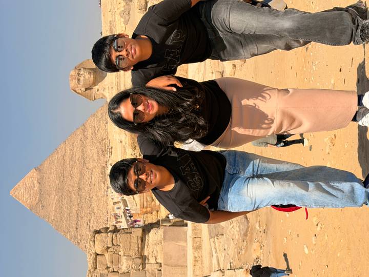 Smiling family poses together with Sphinx and Great Pyramid behind