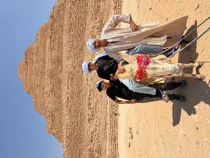 Two boys on donkey with local guide before Step Pyramid of Saqqara