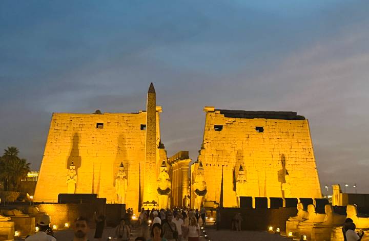 Main pylon of Luxor Temple dramatically lit at twilight with obelisk shadow