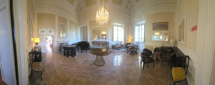 Opulent villa salon with chandelier, grand piano, and antique furnishings