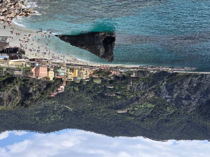 Monterosso al Mare beach with iconic rock formation and turquoise water surrounded by cliffs
