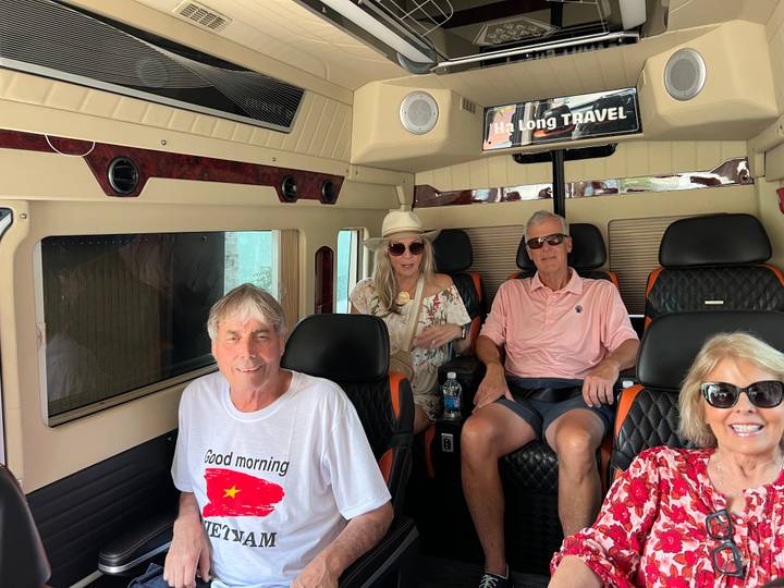 Travelers relax inside a comfortable minibus labeled 'Ha Long Travel' en route to their next destination.