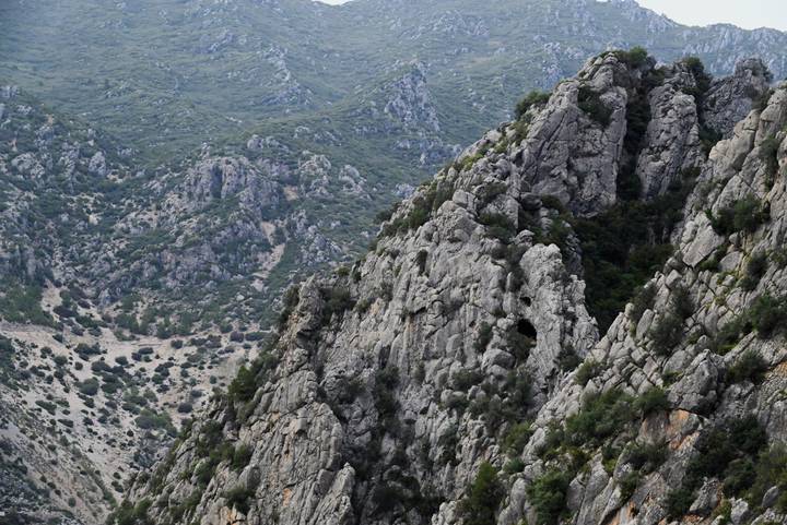 Steep gray limestone ridges rising above a rugged valley in northern Morocco.