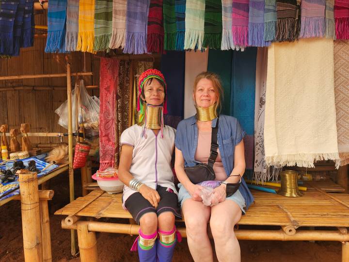 Two women from the Karen long-neck tribe posing with brass coils around their necks