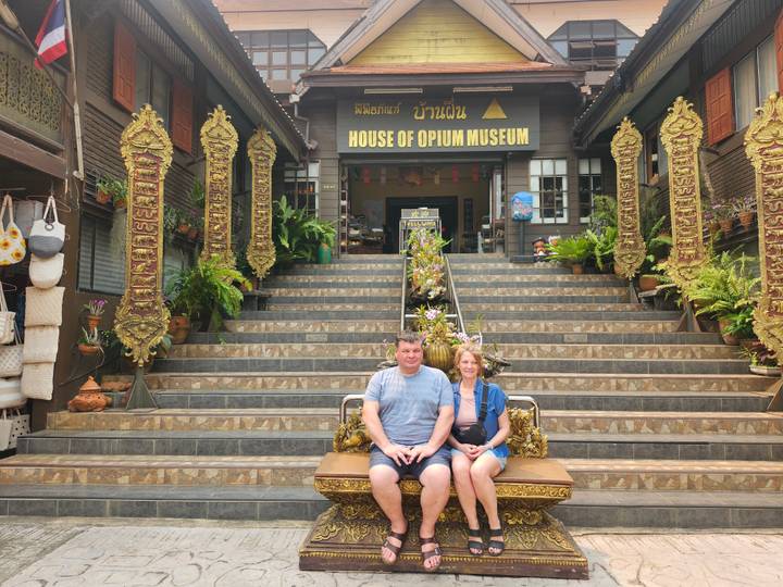 Couple seated on ornate bench outside the House of Opium Museum