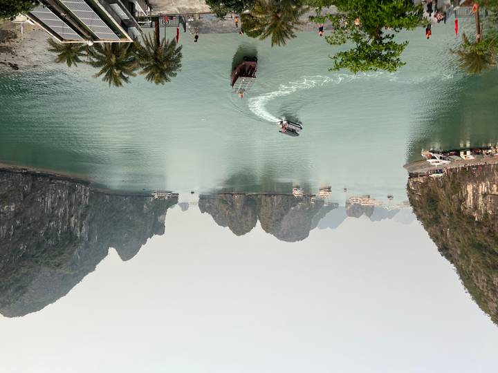 Panoramic view over emerald waters dotted with karst islets and cruising boats