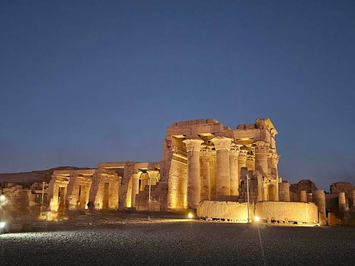 Illuminated columns of Kom Ombo Temple glowing against deep twilight sky.