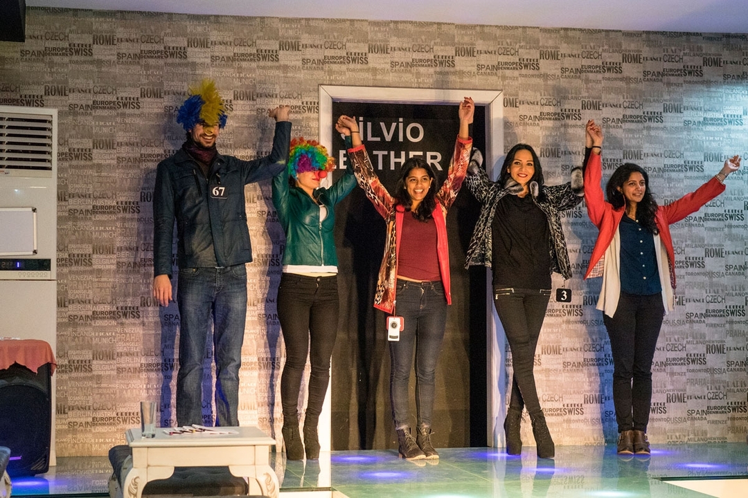 Fashion models with colorful wigs on a runway.