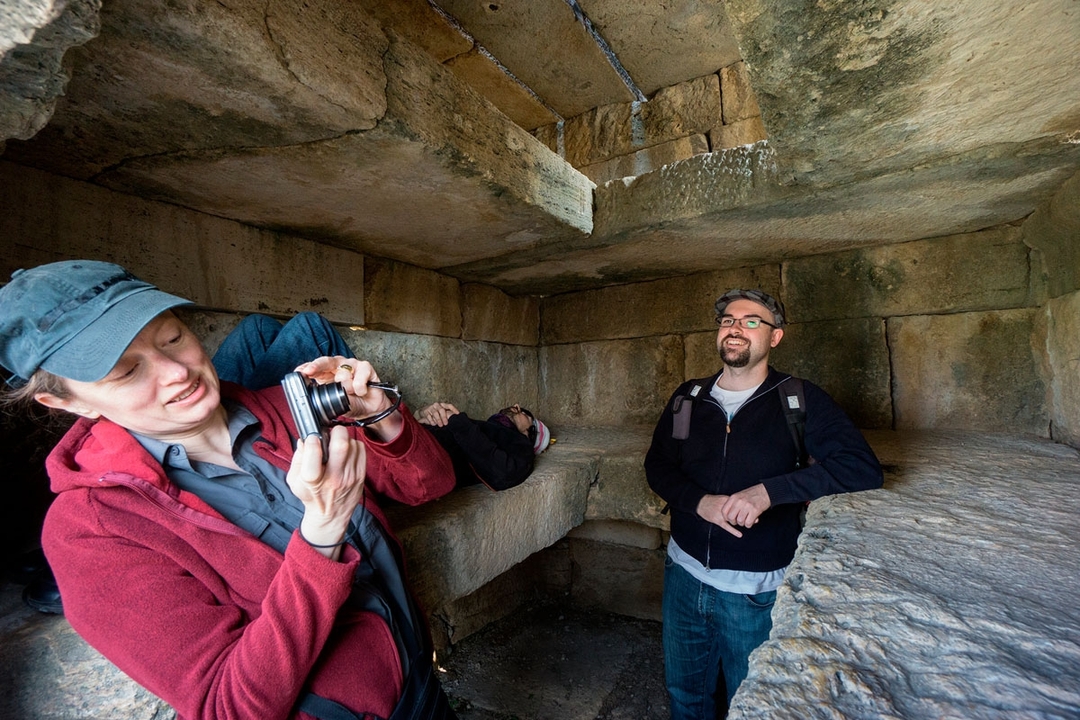 People exploring an ancient stone structure