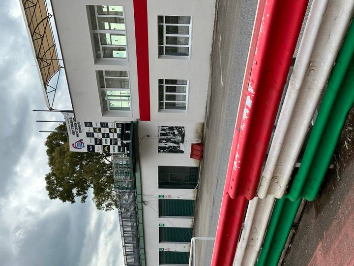 View of a motorsport pit building and track barriers painted red, white and green.