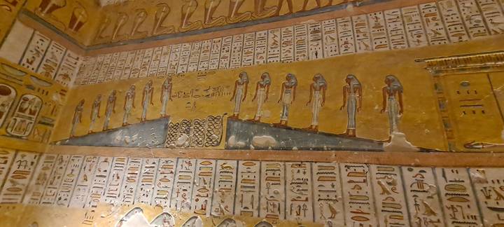 Detailed wall art and hieroglyphs painted inside an Egyptian tomb chamber
