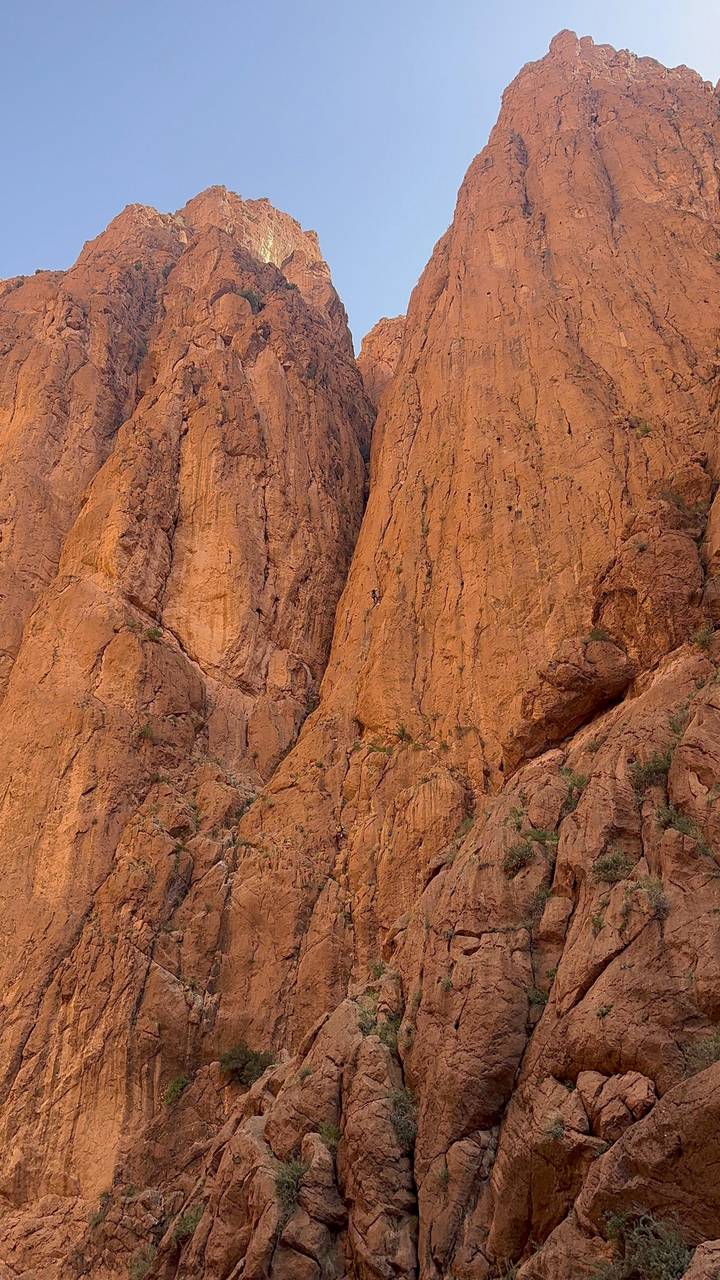 Close-up texture of towering orange sandstone cliffs in Morocco’s Todra Gorge.