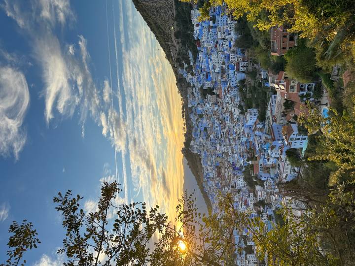 Panoramic sunset view over the blue-washed houses of Chefchaouen nestled on a hillside