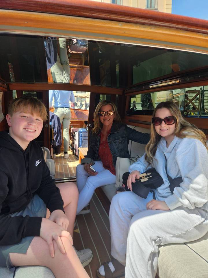 Family seated inside a polished wooden water taxi in Venice ready for departure