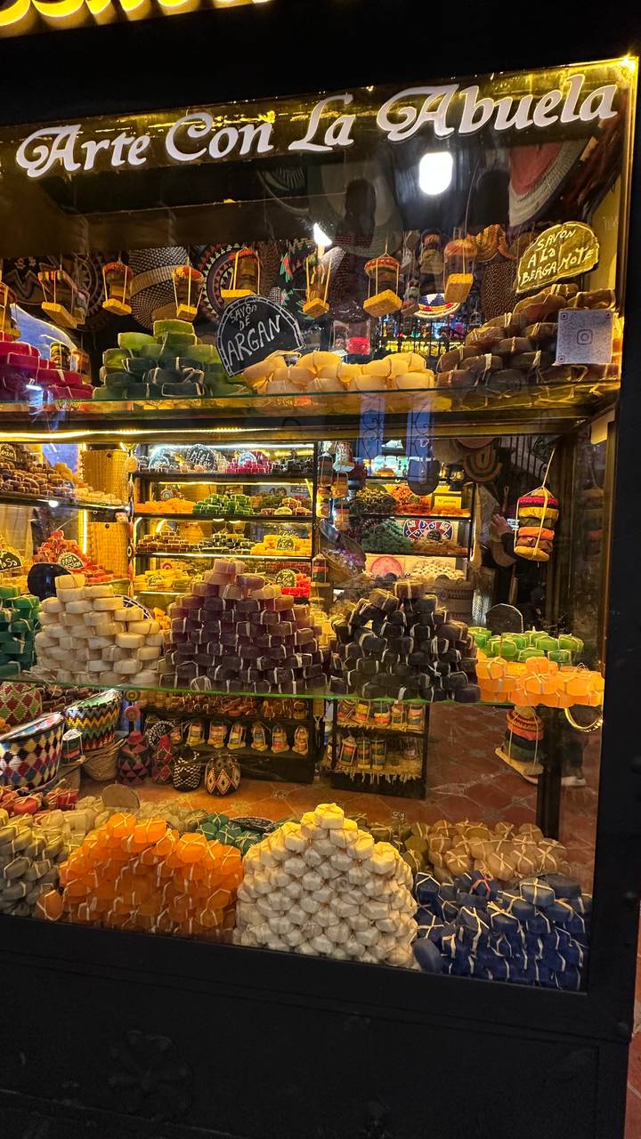 Vibrant stacks of multicoloured soaps and spices fill a souk display case