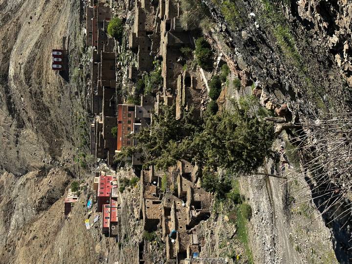 Terraced stone village clings to a rugged mountainside in High Atlas range