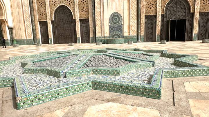 Star-shaped green and blue mosaic fountain in courtyard of Hassan II Mosque