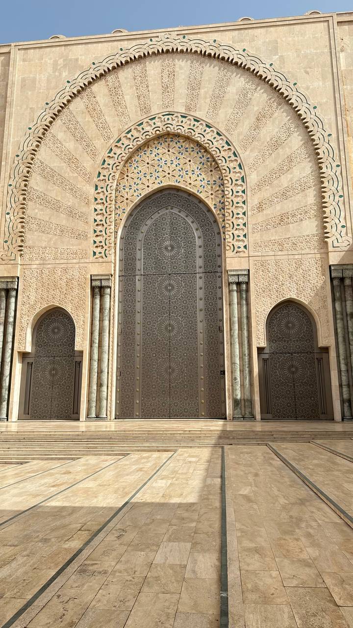 Massive ornate metal door with floral motifs at Hassan II Mosque