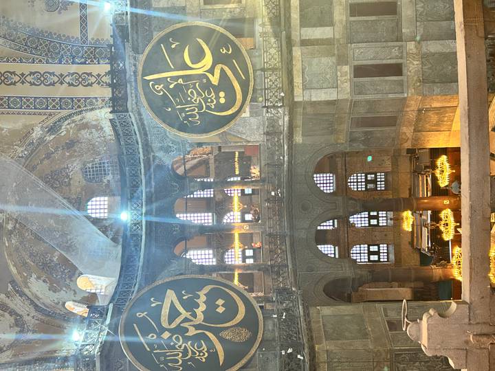 Interior view of Hagia Sophia with Islamic calligraphy and chandeliers.