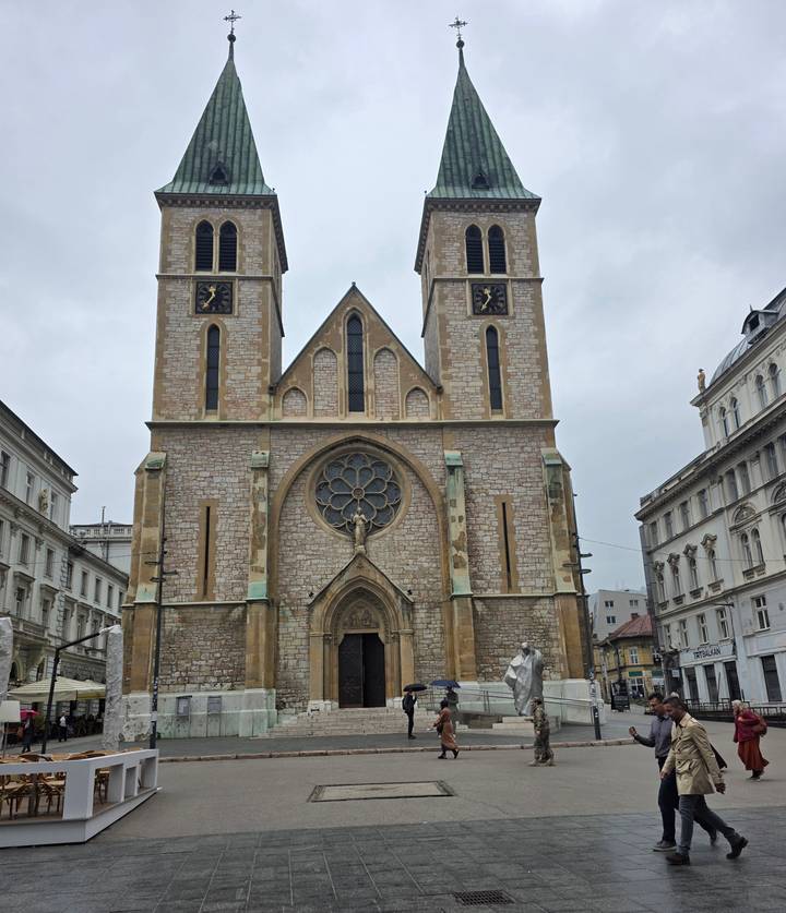 Historic twin-towered cathedral with rose window on a cloudy day