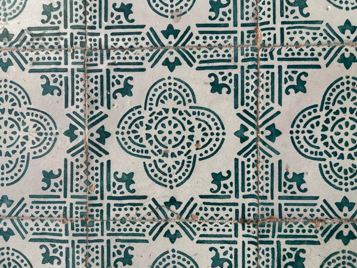 Close-up of ornate green and white Portuguese azulejo tile pattern.