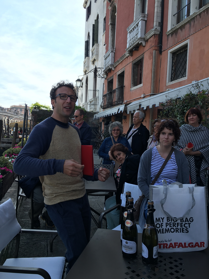 Groupe de personnes écoutant un guide touristique à l'extérieur.