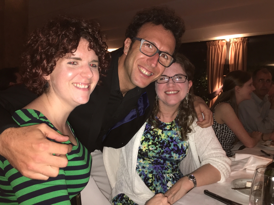 Des personnes sourient pour une photo de groupe pendant le dîner.